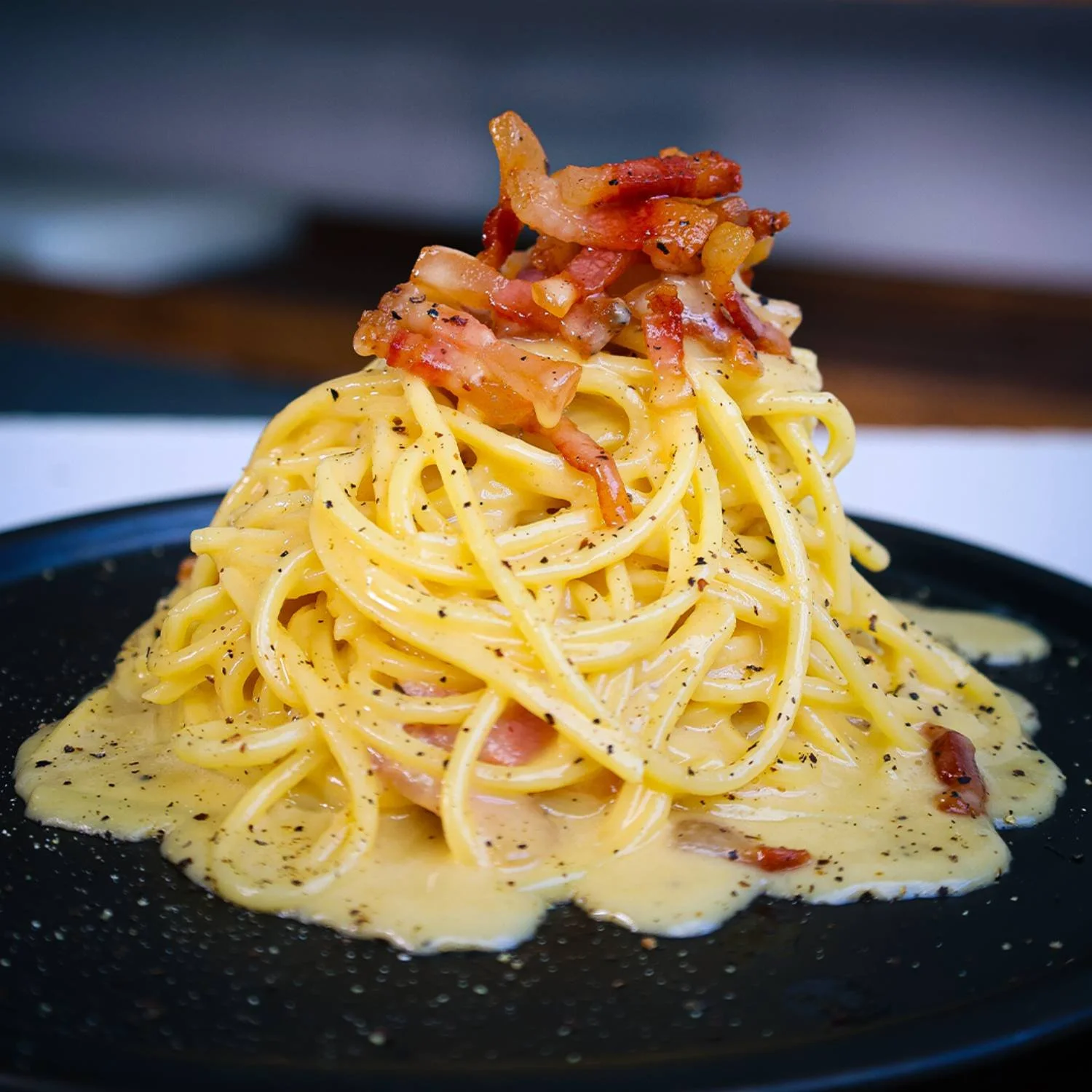 Plat de spaghetti à la carbonara garni de fromage et de pancetta