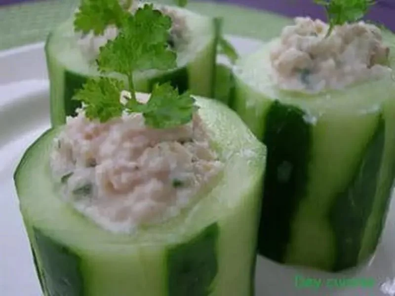 Rouleaux de concombre farcis au saumon sur une assiette blanche